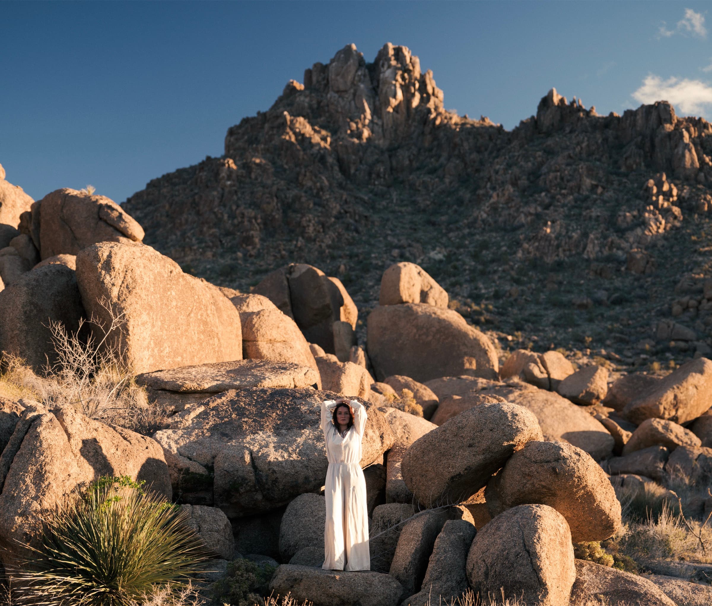 A figure in white in the boulder field with the granite massif rising behind