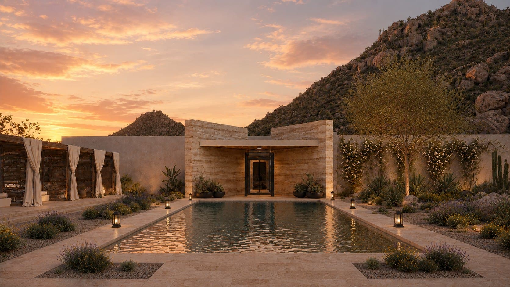 A long rectangular pool in a walled court at sunset, lined with lanterns, with curtained cabanas on one side, a rammed-earth pavilion at the far end and a rocky hillside under an orange sky behind.